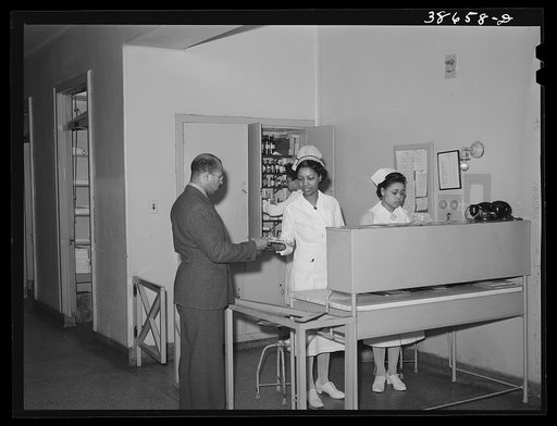 Doctor getting charts from head nurse at Negro hospital. Chicago, Illinois