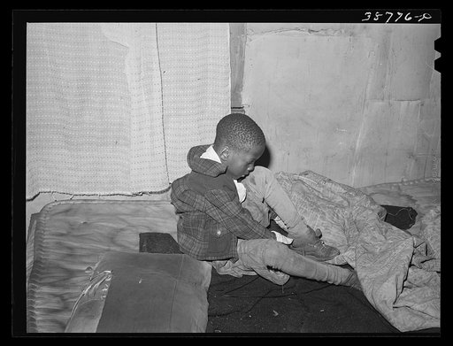 Little boy putting on his shoes. Chicago, Illinois