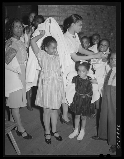 Children putting on choir robes. Pentecostal church. Chicago, Illinois