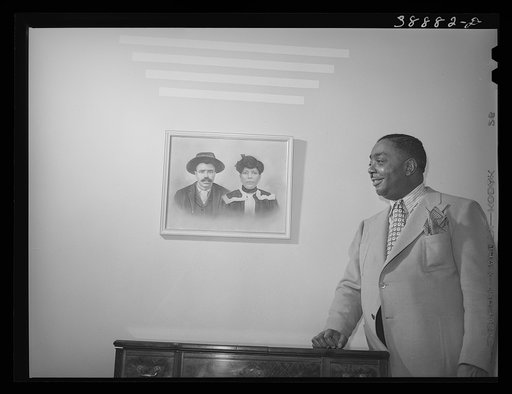 Untitled photo, possibly related to: Prosperous Chicagoan posed by photograph of his parents. Chicago, Illinois