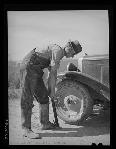 Ray Halstead, FSA (Farm Security Administration) rehabilitation borrower, pumping up a tire. Dead Ox Flat, Malheur County, Oregon