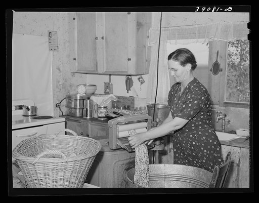 Mrs. Botner, wife of FSA (Farm Security Administration) rehabilitation borrower, wringing laundry in electric wringer. This family has been on the project for about five years. Vale-Owyhee irrigation project, Malheur County, Oregon