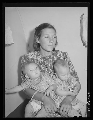 Untitled photo, possibly related to: Mother and her twin babies in the trailer-clinic at the FSA (Farm Security Administration) migratory labor camp mobile unit. Wilder, Idaho