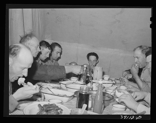 Sheep shearers eating dinner in central tent. Ranch in Malheur County, Oregon. The wife of the owner and boss of the outfit does the kraut and ham, dried beans, canned tomatoes, potatoes, pudding, jams and jellies, coffee and tea