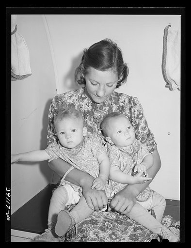 Mother and her twin babies in the trailer-clinic at the FSA (Farm Security Administration) migratory labor camp mobile unit. Wilder, Idaho
