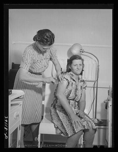 Nurse administers hypodermic to wife of farm worker who lives at the FSA (Farm Security Administration) migratory labor camp mobile unit. Wilder, Idaho