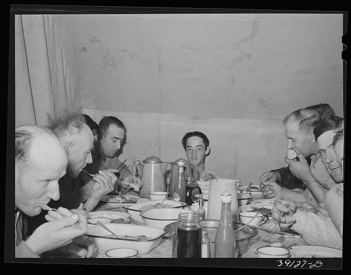 Untitled photo, possibly related to: Sheep shearers eating dinner in central tent. Ranch in Malheur County, Oregon. The wife of the owner and boss of the outfit does the kraut and ham, dried beans, canned tomatoes, potatoes, pudding, jams and jellies, coffee and tea