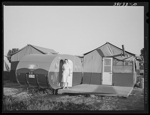 Nurse standing in doorway of trailer-clinic. She lives in the adjoining tent. FSA (Farm Security Administration) migratory labor camp  mobile unit. Wilder, Idaho