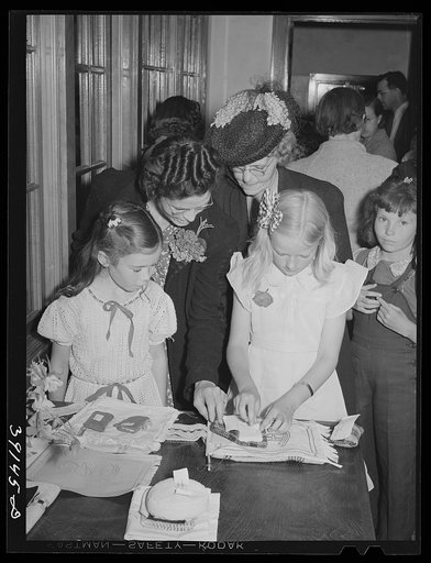 Schoolchildren and their mothers looking at handwork at the 4-H Club Spring fair. Adrian, Oregon