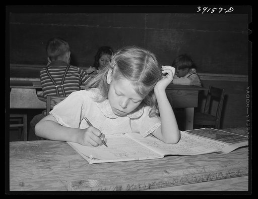 Schoolgirl at the FSA (Farm Security Administration) farm workers' camp. Caldwell, Idaho. Several family units of the row shelters have been thrown open to form a big room for the school