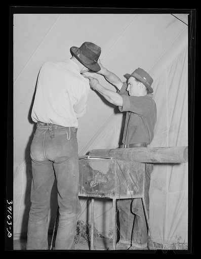 Farm workers fixing up the tent in which they will live at the FSA (Farm Security Administration) migratory labor camp mobile unit. Wilder, Idaho
