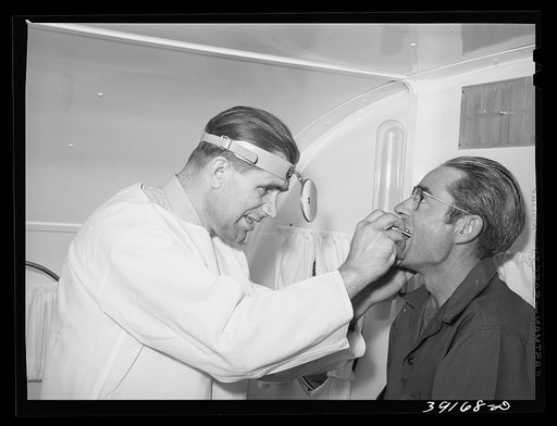 Doctor and farm workers at the FSA (Farm Security Administration) migratory labor camp mobile unit. Wilder, Idaho