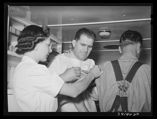 Doctor and nurse and farm worker (patient) at the trailer clinic at the FSA (Farm Security Administration) migratory labor camp mobile unit. Wilder, Idaho. He is getting serum for prevention of wood tick fever