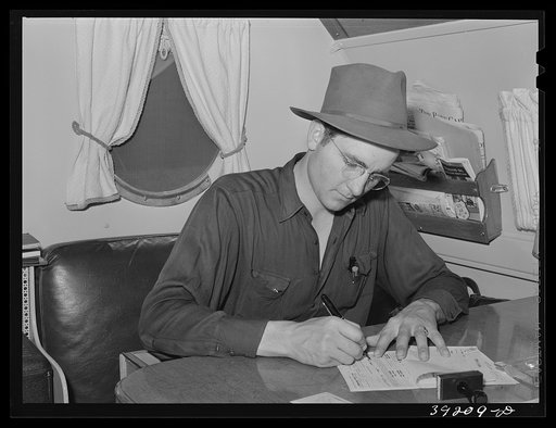 Camp manager in trailer office at the FSA (Farm Security Administration) migratory labor camp mobile unit. Wilder, Idaho