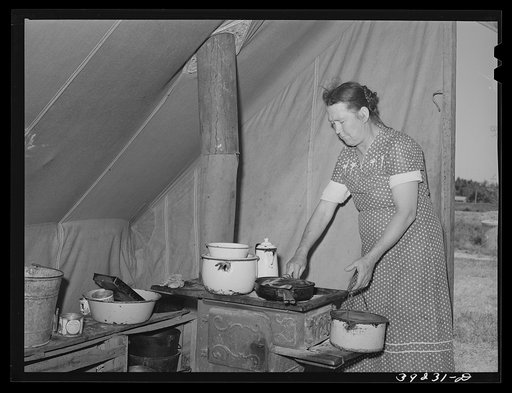 Farm worker's wife prepares dinner. FSA (Farm Security Administration) migratory labor camp mobile unit. Wilder, Idaho