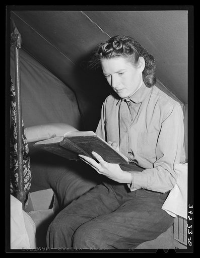 Daughter of farm worker reads her Bible. FSA (Farm Security Administration) migratory labor camp mobile unit. Wilder, Idaho