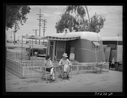 A man who works at Kearney-Mesa (construction work) and his wife in front of their trailer home. San Diego, California
