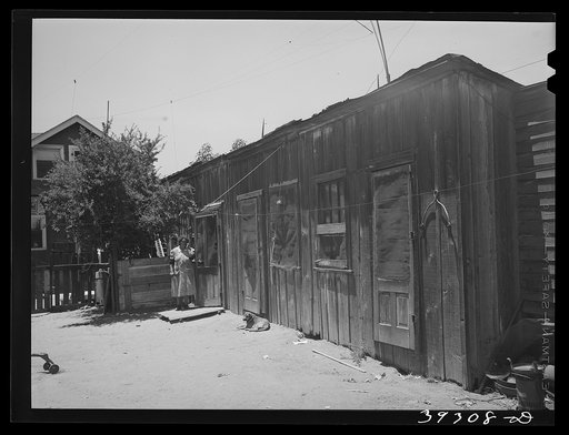 Untitled photo, possibly related to: Houses rented to Mexican families with house of landlady in background. San Diego, California