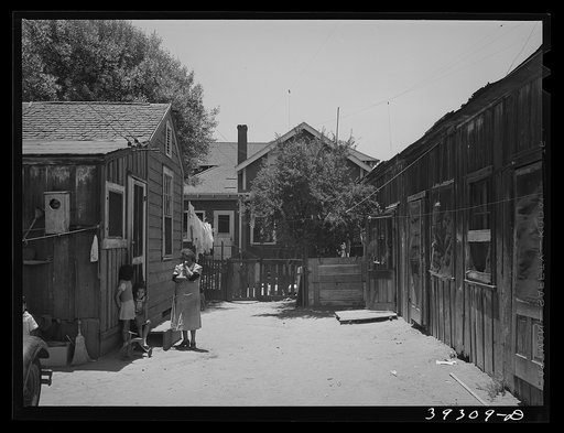 Houses rented to Mexican families with house of landlady in background. San Diego, California