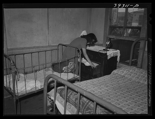 Young Mexican girl in corner of bedroom. San Diego, California