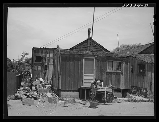 Two little Mexican boys playing in front of their home. San Diego, California