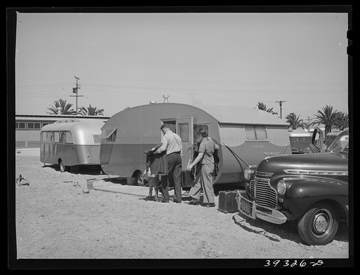 Family moving into trailer at the FSA (Farm Security Administration) camp for defense workers. Before moving to the FSA camp this man had driven fifty-three miles each way daily to work. San Diego, California