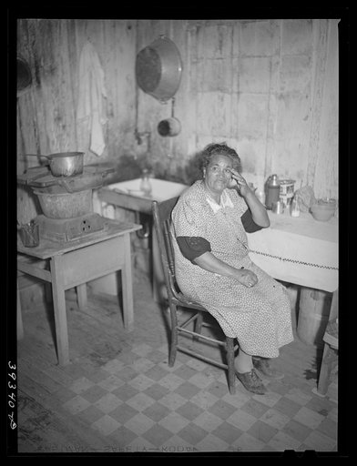 Untitled photo, possibly related to: Mexican woman at table in kitchen of her two-room house. San Diego, California