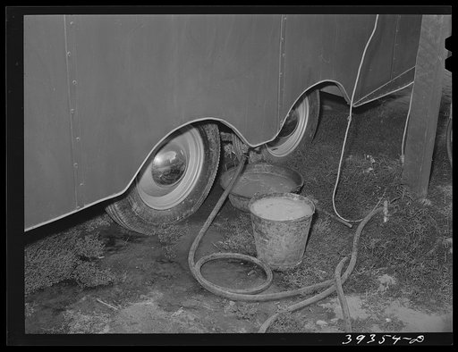 Water from sink in trailer collected in bucket and pan under trailer. This water stands here and spills over on the ground. Such an arrangement is contrary to public health requirements for trailers courts in San Diego and the court will probably be condemned. San Diego, California