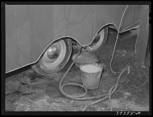 Untitled photo, possibly related to: Water from sink in trailer collected in bucket and pan under trailer. This water stands here and spills over on the ground. Such an arrangement is contrary to public health requirements for trailers courts in San Diego and the court will probably be condemned. Sa