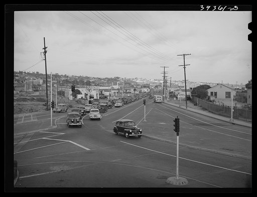 Traffic moving out of town on main highway when Consolidated Aircrafts changes shift in the afternoon. San Diego, California
