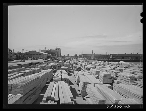 Untitled photo, possibly related to: Lumber for construction work stacked in the open along Pacific Highway. San Diego, California