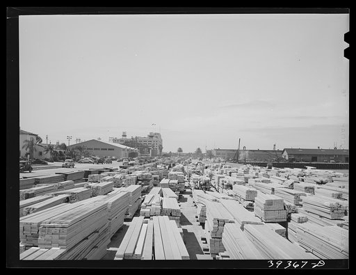 Lumber for construction work stacked in the open along Pacific Highway. San Diego, California
