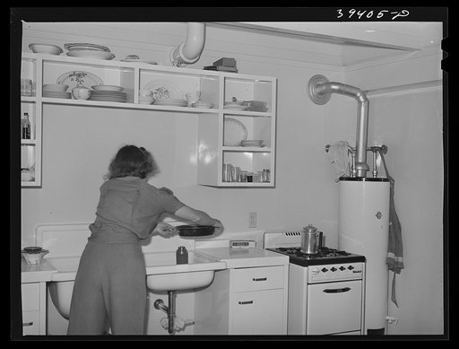 Wife of Marine washing dishes. They live in one of the units of the Navy defense housing project. San Diego, California