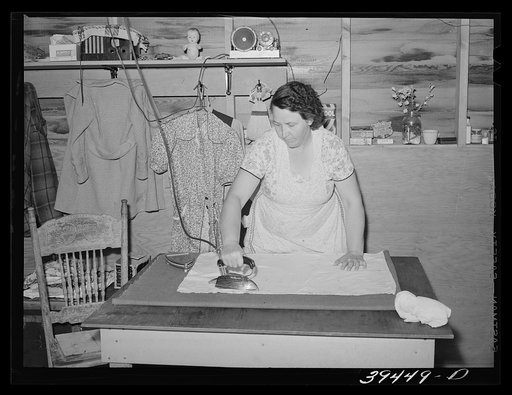 Wife of migratory farm worker ironing in shelter at the FSA (Farm Security Administration) labor camp. Caldwell, Idaho