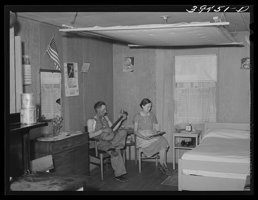 Farm worker and his wife in their cottage at the FSA (Farm Security Administration) labor camp. Caldwell, Idaho. Notice the quilt on frame near the ceiling
