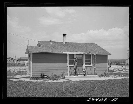 Farm worker and his young son on porch of their cottage at the FSA (Farm Security Administration) labor camp. Caldwell, Idaho. This man is one of the "permanent" farm workers living in the cottages