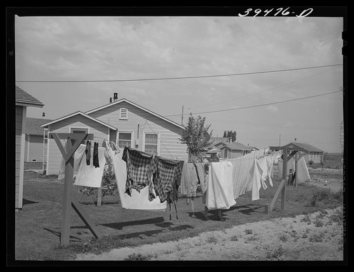 Laundry on line back of cottage of "permanent" farm worker at the FSA (Farm Security Administration) labor camp. Caldwell, Idaho. Here is a community laundry with washing machines, ironing equipment lines, etc. but some of the "permanent" workers living in individual cottages prefer to do their laun
