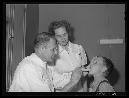 Doctor and nurse with son of farm worker at the clinic at the FSA (Farm Security Administration) labor camp, Caldwell, Idaho