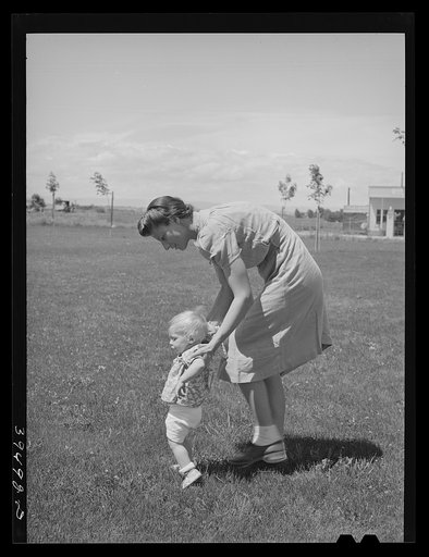 Untitled photo, possibly related to: Farm worker's wife teaches her baby girl to walk a the FSA (Farm Security Administration) labor camp. Cadwell, Idaho