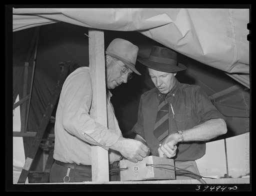 Camp manager, right, and engineer, left, check electrical connection. Mobil unit, FSA (Farm Security Administration) labor camp. Nampa, Idaho