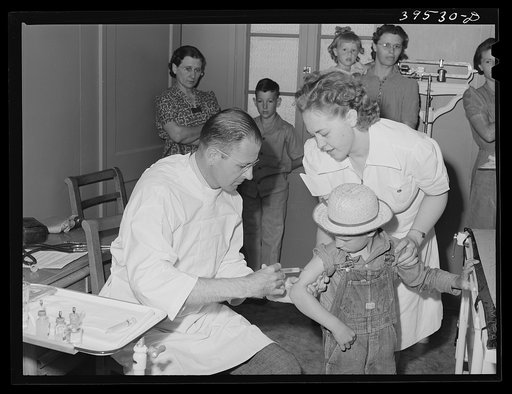 A little boy gets a shot (tick fever serum) at the clinic at the FSA (Farm Security Administration) farm labor camp. Caldwell, Idaho