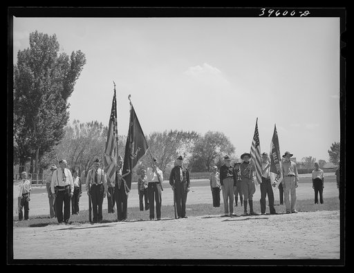Members of the American Legion and Boy Scouts stand at attention while Chief Justice Stone delivered the oath of allegiance over the radio. This was part of the nationwide program on the Fourth of July and in Vale, Oregon, the baseball game was interrupted for those present to hear the speech of Pre