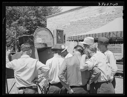 Men gathered around one of the carnival attractions which was in Vale, Oregon, for the Fourth of July celebration