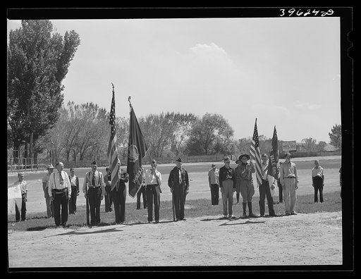 Members of the American Legion and Boy Scouts stand at attention while Chief Justice Stone delivered the oath of allegiance over the radio. This was part of the nationwide program on the Fourth of July and in Vale, Oregon, the baseball game was interrrupted for those present to hear the speech of Pr