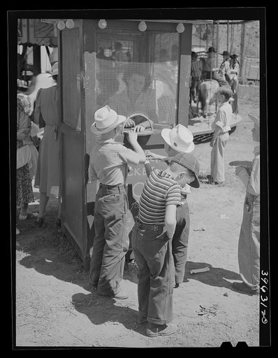 Farm boys buy tickets for ride at the carnival on the Fourth of July. Vale, Oregon