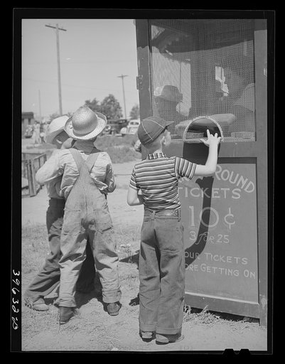 Farm boys buy tickets for ride at the carnival on the Fourth of July. Vale, Oregon