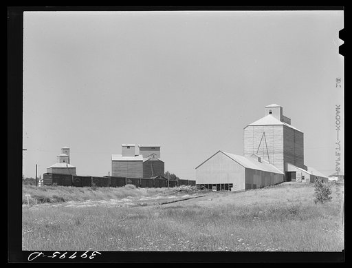 Wheat elevators, sack warehouse and railroad cars. Craigmont, Idaho. Some of these are new elevators--all old elevators were full before the harvest started. All government-owned wheat was being shipped out to make room for the newly harvested crop