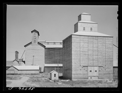 Wheat elevators, sack warehouse and railroad cars. Craigmont, Idaho. Some of these are new elevators--all old elevators were full before the harvest started. All government-owned wheat was being shipped out to make room for the newly harvested crop