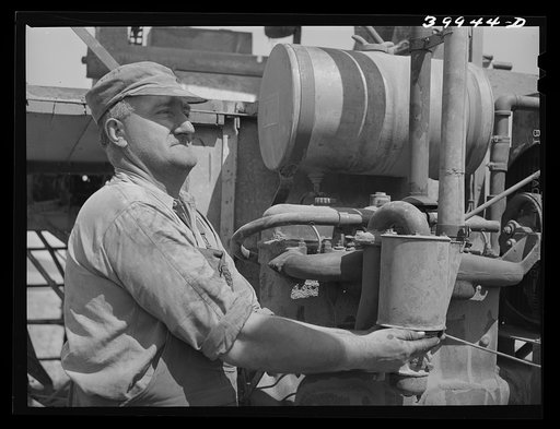 Wheat farmer and his combine. Walla Walla County, Washington