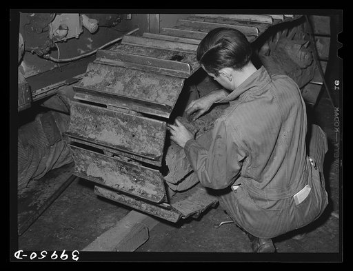 Repairing caterpillar tractor in repair shop at Colfax, Washington